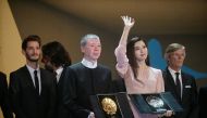 Director Feng Xiaogang holds up the Concha de Oro (Golden Shell) award for best film next to Concha de Plata for best actress award winner Fan Bing Bing, both for the feature film I Am Not Madame Bovary, at the San Sebastian Film Festival. Reuters/Vincent