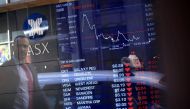 A pedestrian is reflected in a window with a board displaying stock prices at the Australian Securities Exchange (ASX) in Sydney, Australia, September 28, 2016. Reuters/Steven Saphore