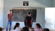 Syrian children sit at a classroom adorned with an Islamic State group insignia on the first day of classes in the Syrian town of Manbij on September 25, 2016.  AFP / Ayham al-Mohammad