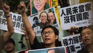 Raphael Wong (C), of the League of Social Democrats, chant slogans during a protest on China's National Day of celebrations in Hong Kong on October 1, 2016. AFP / ISAAC LAWRENCE
