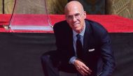 Hollywood producer Jeffrey Katzenberg looks up while writing in the block of cement during his Hand and Footprints ceremony in front of the TCL Chinese Theater in Hollywood, California in September 29, 2016. AFP / FREDERIC J BROWN