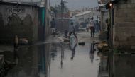 People walk on a flooded street after Hurricane Matthew passes Cite-Soleil in Port-au-Prince, Haiti, October 5, 2016. REUTERS/Carlos Garcia Rawlins
