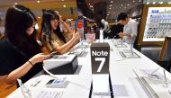 (FILES) A file photo shows visitors testing Samsung Galaxy Note7 smartphones at a Samsung showroom in Seoul. AFP / JUNG YEON-JE