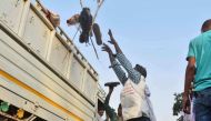 A man loads a truck with footwear of victims of a stampede on a crowded bridge on the outskirts of Varanasi. / AP