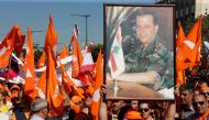 Supporters of the Free Patriotic Movement (FPM) carry flags and a picture of FPM founder and politician Michel Aoun during a rally to show support for Aoun and calling to elect a president, near the presidential palace in Baabda, near Beirut, Lebanon Octo