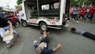 Protesters lie on the ground after being hit by a police van during a rally in front of the US embassy in Manila on October 19, 2016 ©Rob Reyes (AFP)