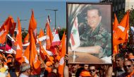 Supporters of the Free Patriotic Movement (FPM) carry flags and a picture of Christian politician and FPM founder Michel Aoun during a rally to show support for Aoun and calling to elect a president, near the presidential palace in Baabda, near Beirut, Le