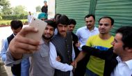 Arshad Khan (C), formerly a chai wala (tea seller) by profession, posses for a selfie with fans after doing a television interview in Islamabad, Pakistan October 20, 2016. (Reuters/Faisal Mahmood)