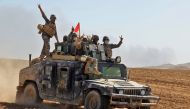 Iraqi government forces flash the sign for victory as they advance towards the village of Tal al-Shawk on the eastern bank of the Tigris river on October 20, 2016, during the ongoing operation to retake Mosul from the Islamic State (IS) group. The operati
