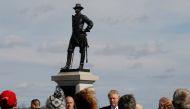 Tourists look on as Republican U.S. presidential nominee Donald Trump (C) visits Gettysburg National Military Park, site of an important battle in July 1863 during the U.S. Civil war, in Gettysburg, Pennsylvania, U.S. October 22, 2016. (REUTERS/Jonathan E