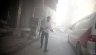Men walk amidst dust after shelling in the rebel held besieged town of Douma, eastern Ghouta in Damascus, Syria October 20, 2016. REUTERS/Bassam Khabieh
