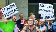 A PSOE supporter holds placards reading 