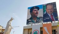 A general view shows a large poster bearing portraits of ex-general Michel Aoun and reading in Arabic: 