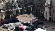 Indian police gather alongside the bodies of SIMI activists, who allegedly escaped from Central Jail in Bhopal and were killed in highly suspicious circumstances by Special Task Force police at the hillocks of Acharpura village, near Bhopal on October 31,