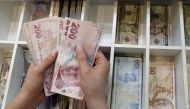 A money changer counts Turkish lira bills at a currency exchange office in central Istanbul, Turkey, August 21, 2015. (REUTERS / Murad Sezer) 