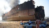 A Pakistani man looks at the wreckage of a burning ship a day after a gas cylinder explosion at the Gadani shipbreaking yard, some 50 kilometres (30 miles) west of Karachi, on November 2, 2016.  AFP / RIZWAN TABASSUM