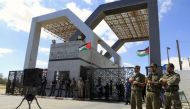 A picture taken on September 16, 2013 shows members of Hamas’ security forces standing guard in front of the Rafah border crossing with Egypt in the southern Gaza Strip as demonstrators gather demanding it to be open permanently and without restrictions o