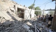 People stand on the rubble of a prison struck by Arab coalition warplanes in al-Zaydiyah district of the Red Sea port city of Hodeidah, Yemen Oct. 30, 2016. / Reuters.