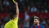 Barcelona's Argentinian forward Lionel Messi (R) is shown a yellow card during the Spanish league football match Sevilla FC vs FC Barcelona at the Ramon Sanchez Pizjuan stadium in Sevilla on November 6, 2016. / AFP / JORGE GUERRERO