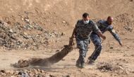 Iraqi forces pull a body out from a mass grave they discovered in the Hamam al-Alil area on November 7, 2016 after they recaptured the area from Islamic State (IS) group jihadists during the ongoing operation to retake Mosul, the last IS-held Iraqi city. 