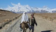 An Afghan woman, wearing a burqa, rides on a donkey alongside her husband in the Ishkashim district of Badakhshan province, north east of Kabul April 24, 2008. REUTERS/Ahmad Masood