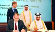Essa bin Hilal Al-Kuwari (right) and Markus Berger signing  the document in the presence of Minister of Energy and Industry, H E Dr Mohammed bin Saleh Al Sada yesterday. Pic: Abdul Basit / The Peninsula