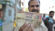 An Indian man display the currency of 500 and 1,000 rupees (15 USD) in Hyderabad on November 9, 2016. Indian Prime Minister Narendra Modi announced late November 8 that 500 and 1,000 rupee notes will be withdrawn from financial circulation from midnight, 