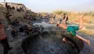 People with Iraqi security forces swim in a sulphur pond in Hammam al-Ali, south of Mosul, Iraq November 9, 2016. REUTERS/Alaa Al-Marjani
