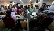 People stand in a queue to deposit 500 and 1000 Indian rupee banknotes inside a bank in the northern city of Kanpur, India, November 10, 2016. REUTERS/Adnan Abidi