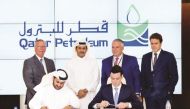 Saad Sherida Al-Kaabi (standing second left) and other officials witnessing the signing ceremony.