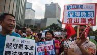 Pro-Beijing demonstrators hold placards outside the Hong Kong Legislative Council on November 13, 2016.  AFP / ISAAC LAWRENCE