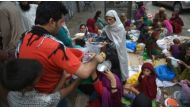 A Pakistani man distributes rice to Afghan refugees gathered outside a food distribution center before breaking their fast during the Muslim holy month of Ramadan in Islamabad on June 20, 2016. (AFP)