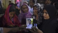 DEADLY BOMBING. Pakistani women show photos of missing relatives outside a hospital in Karachi on November 12, 2016, following a suicide bombing at a Sufi shrine. Photo by Rizwan Tabassum/AFP.