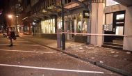 Debris from fallen concrete off buildings are seen on a sidewalk past a cordon line in Wellington early on November 14, 2016 following an earthquake centred some 90 kilometres (57 miles) north of New Zealand's South Island city of Christchurch. AFP / Mart