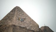Belgian pilots Alexandra Maingard and her husband Cedric Collette fly their vintage Stampe OO-GWB biplane by one of the Pyramids of Giza, on the southern outskirts of the Egyptian capital Cairo on November 13, 2016 during the Vintage Air Rally (VAR). A do