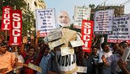 Activists of Socialist Unity Centre of India (SUCI) shout slogans as they carry an effigy of Prime Minister Narendra Modi during a protest against the government's decision to withdraw 500 and 1000 Indian rupee banknotes from circulation, according to a m