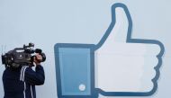 A videographer shooting the side of Facebook Like Button logo displayed at the entrance of the Facebook Headquarters in Menlo Park, California, May 18, 2012.  (AFP) 