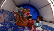 A woman who fled from Mosul sits with her daughters Nada, 8 months old, and Houda (R), 2, who were both born under Islamic State rule and have no identity documents recognised by Iraqi authorities, inside their tent in Khazer refugee camp, Iraq November 1