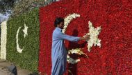 A Pakistani worker decorates a welcoming Turkish national flag with flowers on the arrival of Turkish President Recep Tayyip Erdogan in Lahore on November 17, 2016. Turkish President Recep Tayip Erdogan is in Islamabad on a two-day official visit to meet 