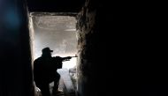 A fighter of Libyan forces allied with the U.N.-backed government aims his weapon as he takes up position inside a ruined house at the front line of fighting with Islamic State militants in Ghiza Bahriya district in Sirte, Libya November 9, 2016. Picture 