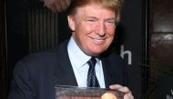 (FILES): This file photo taken on May 22, 2005 shows real estate mogul Donald Trump holding a book at a media conference announcing the establishment of Trump University in New York City.  AFP / Thos Robinson
