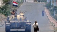 A fighter loyal to Yemen's exiled President Abd Rabbuh Mansour Hadi runs behind a tank near the city of Taiz on 7 September 2016 (AFP)