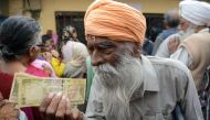 Indian senior citizens gather outside a bank as they wait to deposit and exchange 500 and 1000 rupee notes in Amritsar on November 19, 2016. AFP / NARINDER NANU