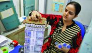 A cashier stacks Indian currency notes inside a bank in Chandigarh, India.