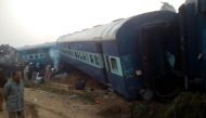 A man walks past the wreckage of an Indian train that derailed near Pukhrayan in Kanpur district on November 20, 2016. (AFP)