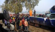 Rescue worker and onlookers stand near the wreckage of the train on the damaged tracks where a train derailed near Pukhrayan in India's Kanpur district on November 21, 2016. AFP / SANJAY KANOJIA