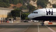 Pedestrians and drivers wait to cross the road of the Gibraltar international airport as an aircraft taxis on the tarmac, August 2013, (Reuters / Jon Nazca)
