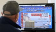 A man evacuated from his home looks at a television screen showing a news report on tsunami warnings, at a shelter following an earthquake, in Sendai, Japan, in this photo taken by Kyodo November 22, 2016. Kyodo via Reuters 