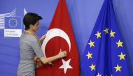 Filephoto of a woman adjusting the Turkish flag next to the European Union flag at the EU Commission. Reuters 
