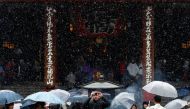 Tourists are seen during the first November snowfall in 54 years in Tokyo, at Senso-ji Temple in Tokyo's Asakusa district, Japan, November 24, 2016. REUTERS/Toru Hanai

